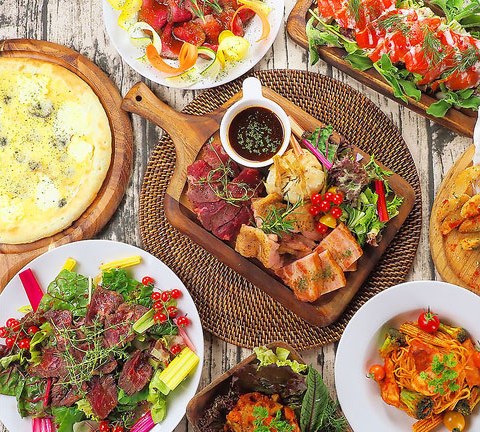 テーブルいっぱいに並んだ肉料理やチーズのごちそうを真上から捉えた写真